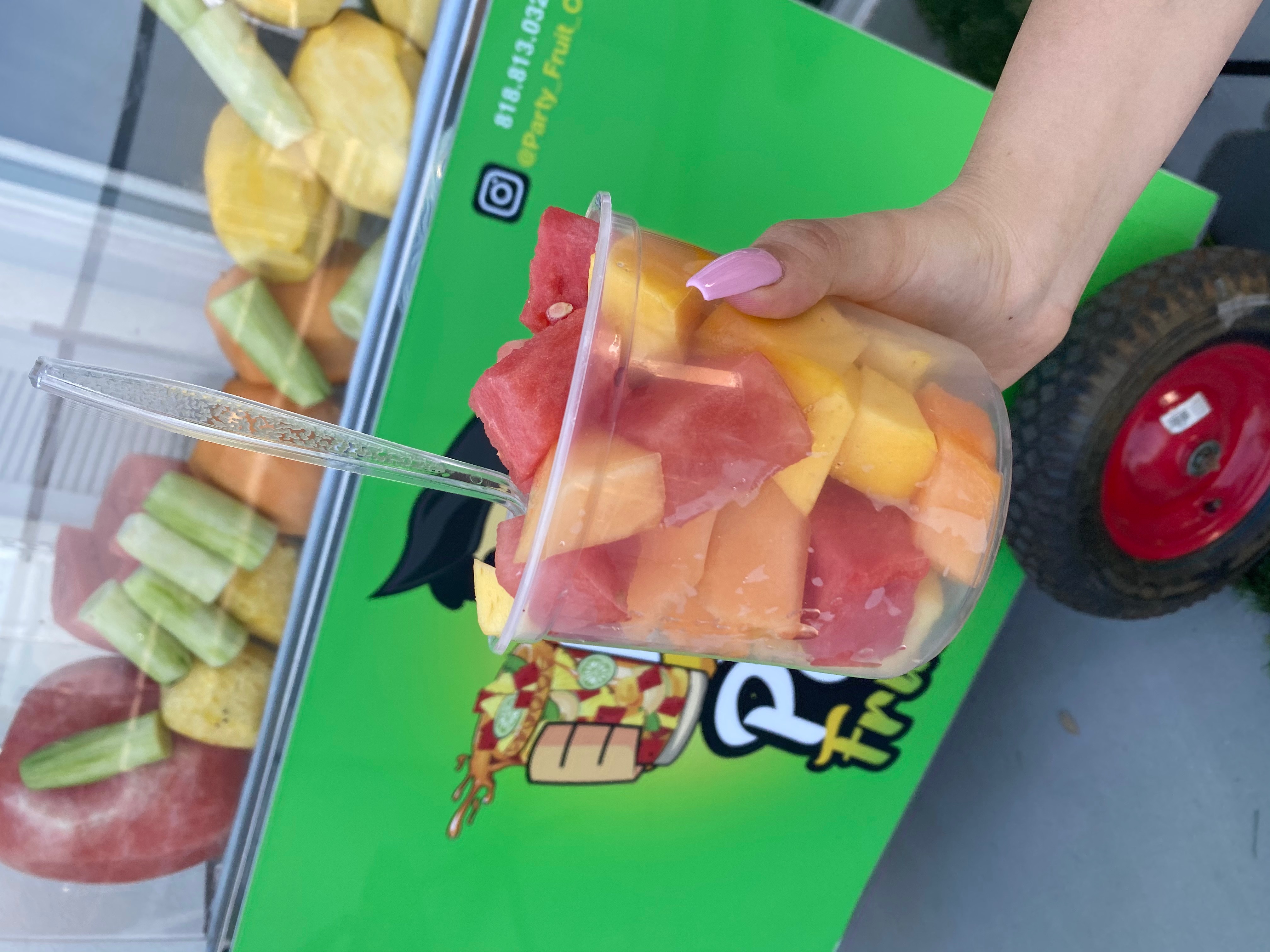 Fresh fruit cup held in front of the cart