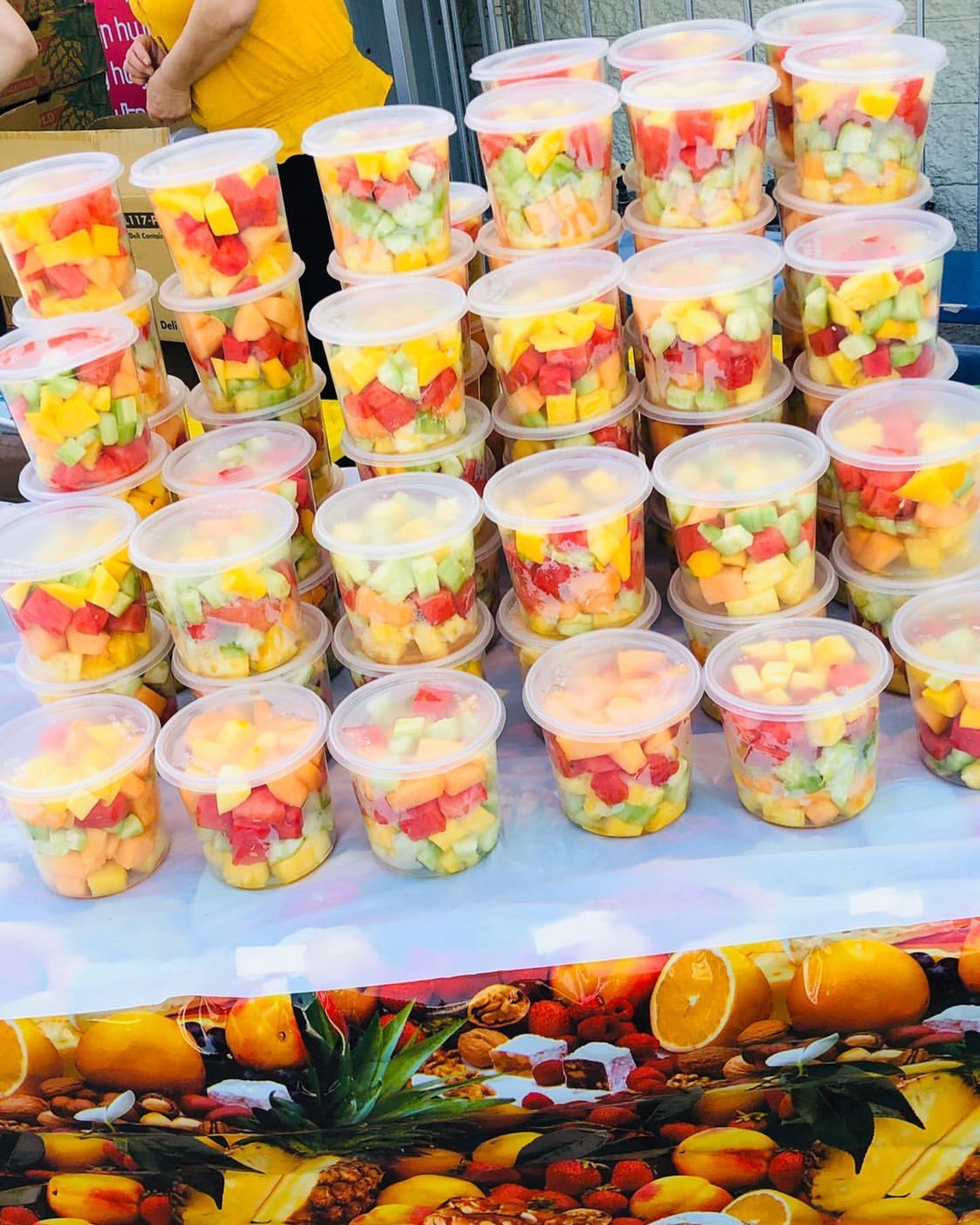 Rows of fresh mixed fruit cups ready for service